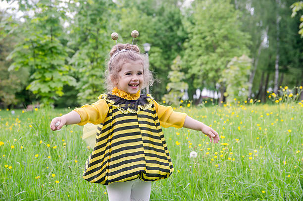 beautiful girl in a suit bee at park. Happy child beautiful girl in a suit bee at park. Happy child bee costume stock pictures, royalty-free photos & images