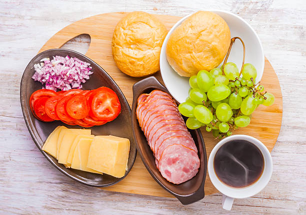 istock Board with breakfast ingredients: bread, cheese, ham, tomatoes, coffee 475501560