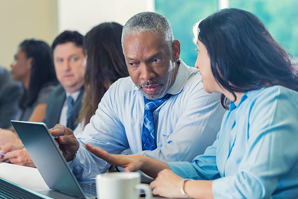 istock Diverse professionals studying financial information in conference or seminar 475503898