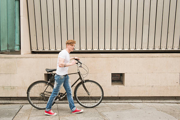 ハンサムな男、彼の自転車をご堪能いただけます。 - dublin ireland urban road people real people ストックフォトと画像