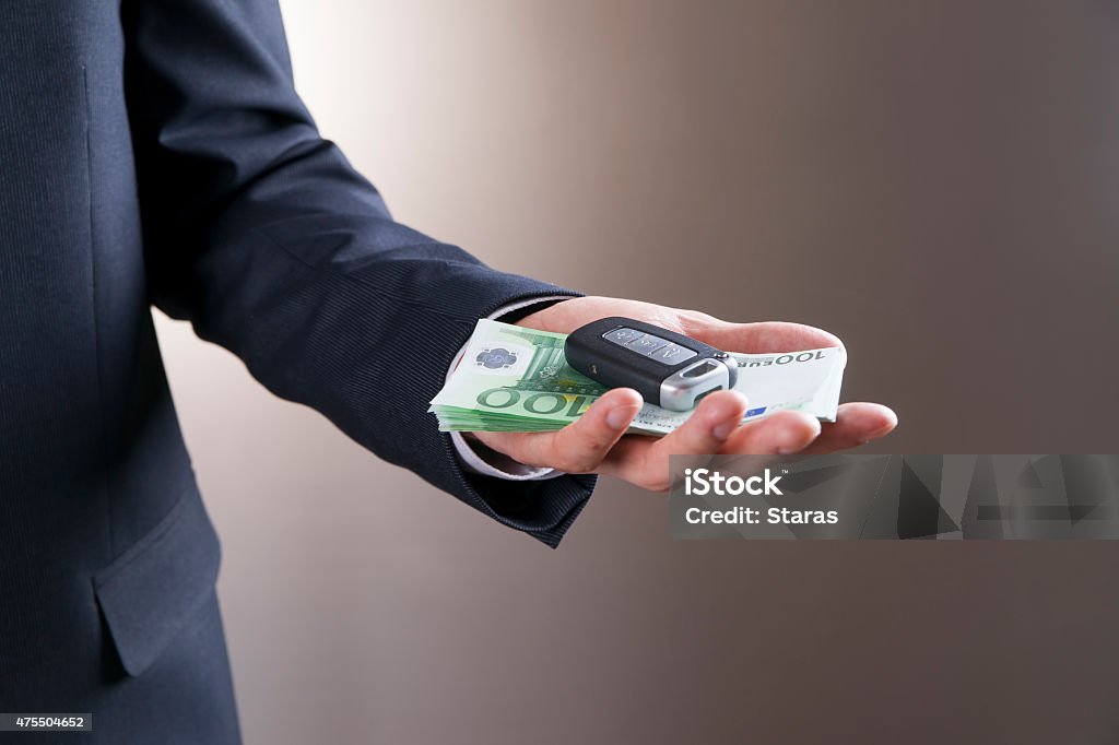Businessman using car key and money Businessman using car key and money. Keyless in male hand 2015 Stock Photo