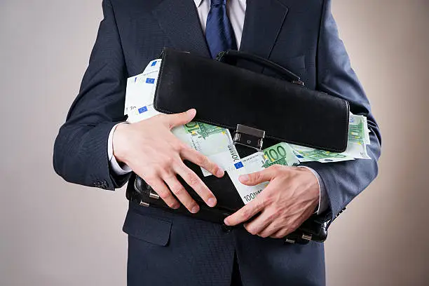 Photo of Businessman with a briefcase full of money