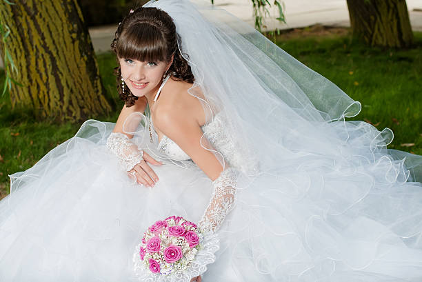 istock Young beautiful bride in wedding dress with a bouquet 475506257