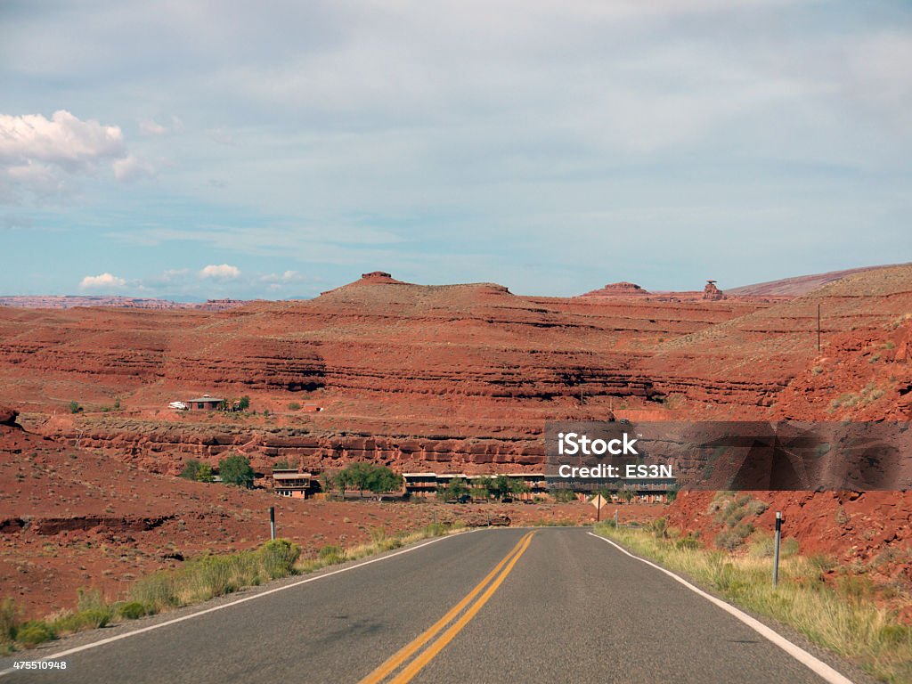 Road to Mexican Hat Desert Road in Utah, red desert landscape with hills and Mexican Hat balanced rock in background Desert Area Stock Photo