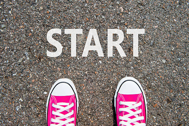 istock Feet concept with pink sneakers on black background 475511626