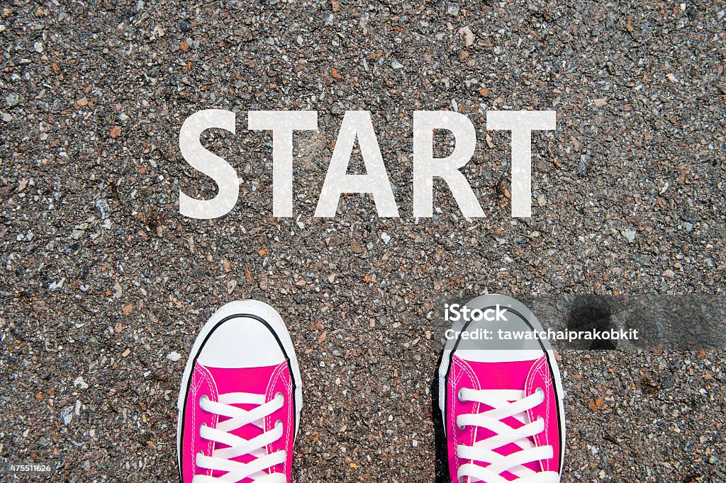 Feet concept with pink sneakers on black background Feet concept with pink sneakers on black background with start text. Starting Line Stock Photo
