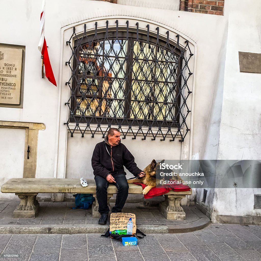 Man with dog begging in Warsaw old town Krakow, Poland - April 30, 2015: Man with dog begging in Warsaw old town 2015 Stock Photo