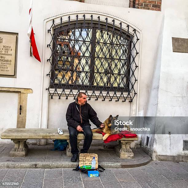 Man With Dog Begging In Warsaw Old Town Stock Photo - Download Image Now - 2015, Adult, Asking