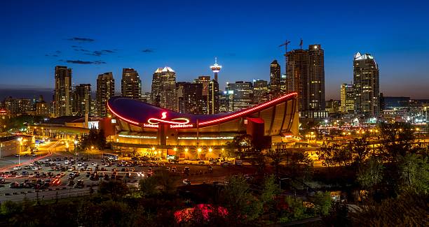 Calgary skyline at night Calgary, Canada - May 23, 2015: Calgary's skyline at night with with the Scotiabank Saddledome in the foreground. The dome with its unique saddle shape is home to the Calgary Flames NHL club, and is one of the oldest professional hockey arenas in North America. scotiabank saddledome stock pictures, royalty-free photos & images