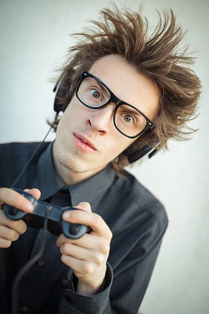 nerd joven jugando videojuegos - retro revival video game joystick gamer fotografías e imágenes de stock