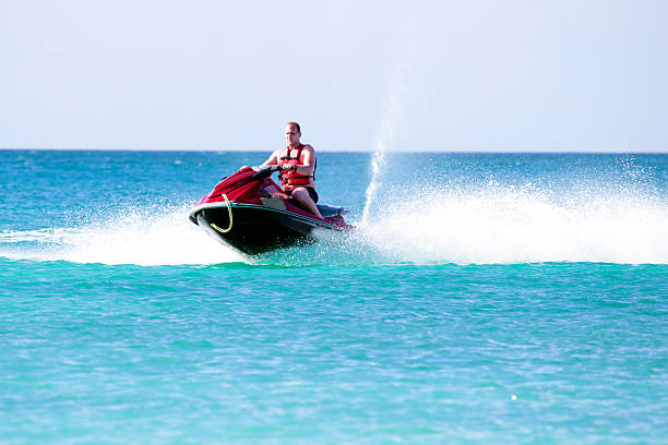 istock Young guy  on a jet ski on the caribbean sea 475517880