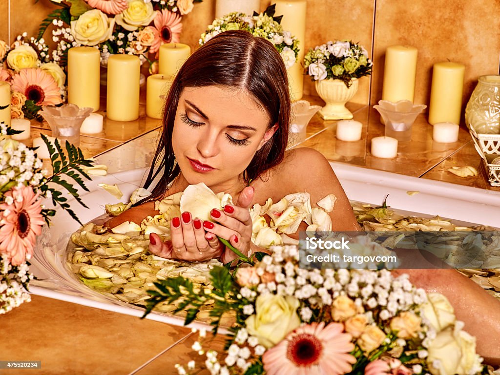 Woman at luxury spa Woman looking down relaxing at flower water spa. Nice smiling. 2015 Stock Photo