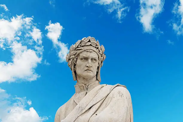 dante alighieri statue under a blue sky with clouds