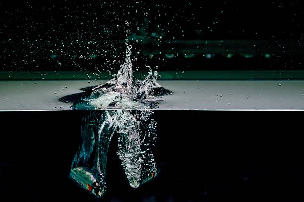 istock Red apple splashing into water, isolated on black background 475522942