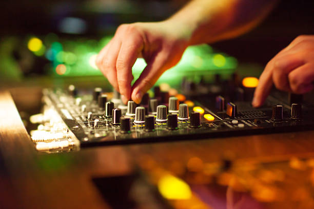 DJ mixing music on console at the night club stock photo