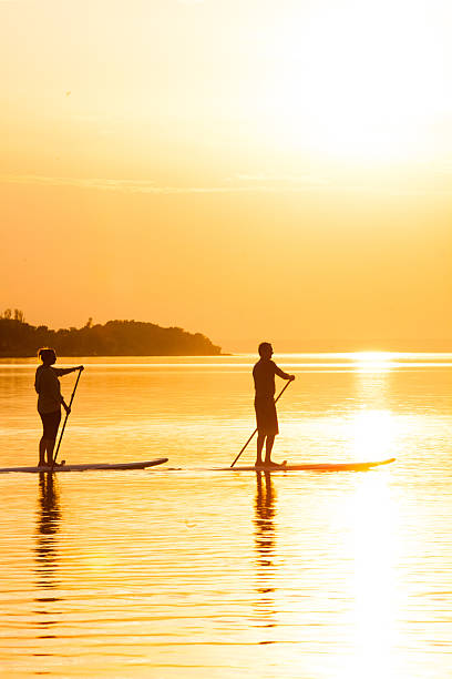 istock Couple Stand Up Paddle Boarding at Sunset 475526528