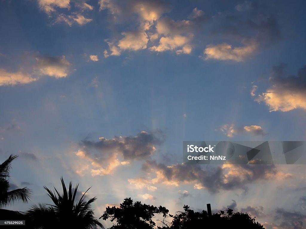 sunlight rays through clouds at sunrise Backgrounds Stock Photo