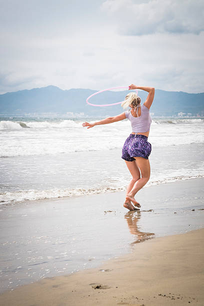 istock Female hoola hoop performer at a beach in Mexico. 475532998