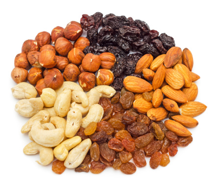 Mixed nuts and dry fruits pile isolated on white background