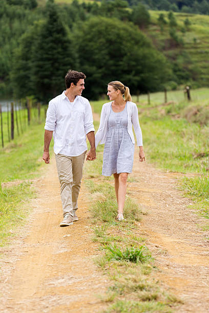 istock couple holding hands walking in countryside 475536598