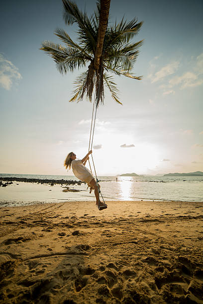 istock Young woman on a swing in a tropical Island. 475536619