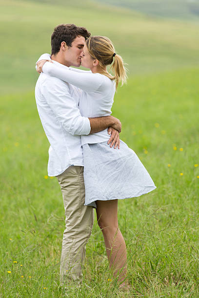 istock young couple kissing on green field 475540552