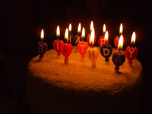 istock Birthday cake with lighted baloon candles 475543422