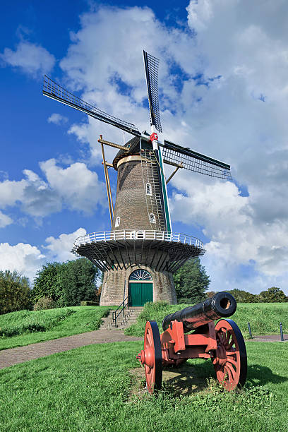istock Ancient floor mill on city wall with red canon, Netherlands 475543928