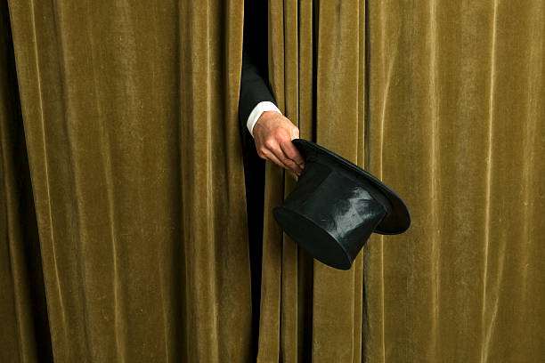 istock Actor with opera hat appears from behind the curtain. 475545443
