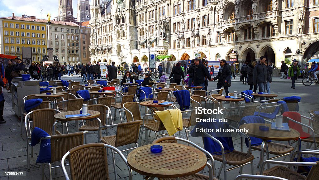 Munich marienplatz Munich, Germany - February 22, 2014: View of an open café on the Marienplatz with the town hall in the background. Passing tourists to be seen and a couple sitting outside on a table in February. It was a sunny unusual warm day in winter. 2014 Stock Photo