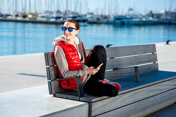 sport frau auf die promenade - women sweater vest beach pier stock-fotos und bilder