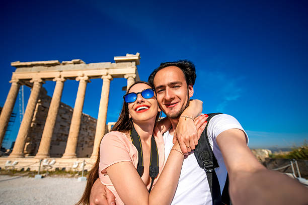 istock Young couple taking selfie picture with Erechtheum temple on background 475555562
