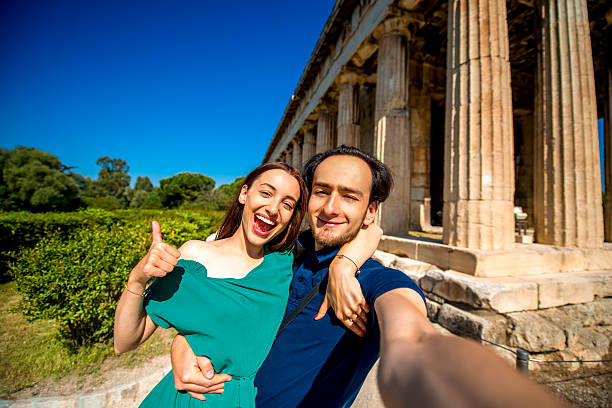 istock Young couple taking selfie picture with Hephaistos temple on background 475555564