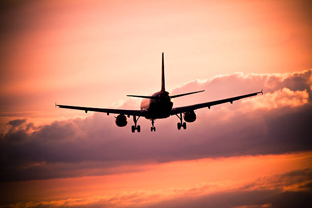 istock Airplane landing at sunset 475555895
