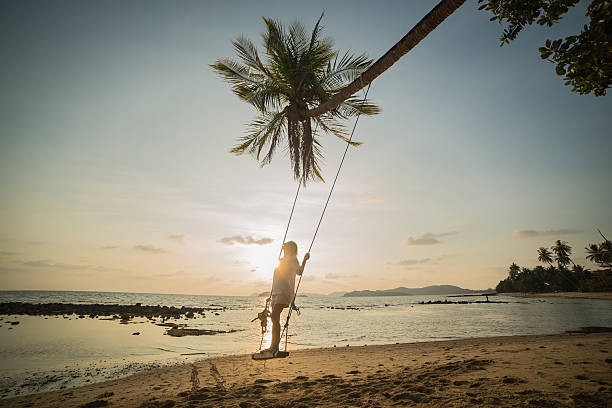 istock Young woman on a swing in a tropical Island. 475557033