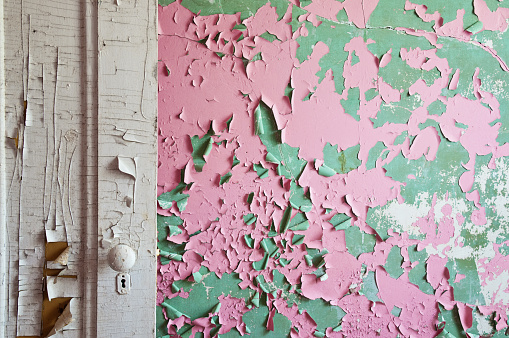 Paint peeling off the wall and door of an abandoned house
