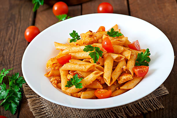 istock Penne pasta in tomato sauce with chicken, tomatoes 475562318