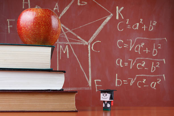 Schoolboy doll and books Student sees the level of books, apple and blackboard pythagoras stock pictures, royalty-free photos & images