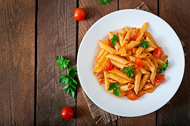 istock Penne pasta in tomato sauce with chicken, tomatoes 475563268