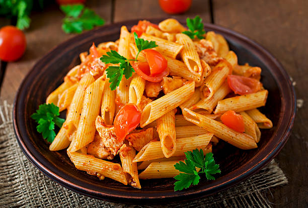 istock Penne pasta in tomato sauce with chicken, tomatoes 475563484
