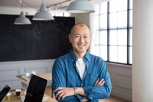 Portrait of a casual Japanese man in modern office. Asian businessman smiling to camera.