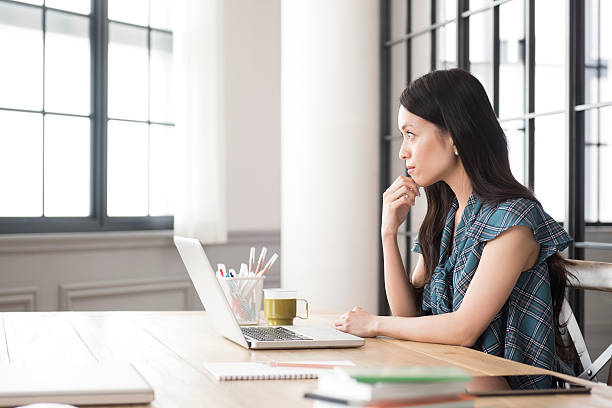 istock Thoughtful young Asian woman at work 475566470