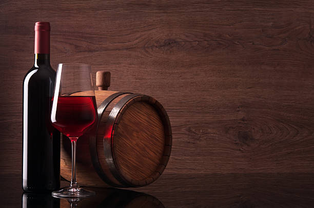 Botella de vino tinto, el vidrio y cilindro sobre fondo de madera - foto de stock