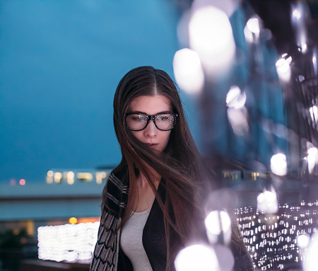 Woman wearing eyeglasses and beautiful bokeh at night. Concept for loneliness,sadness and urban lifestyle. Image is taken during Tokyo istockalypse 2015