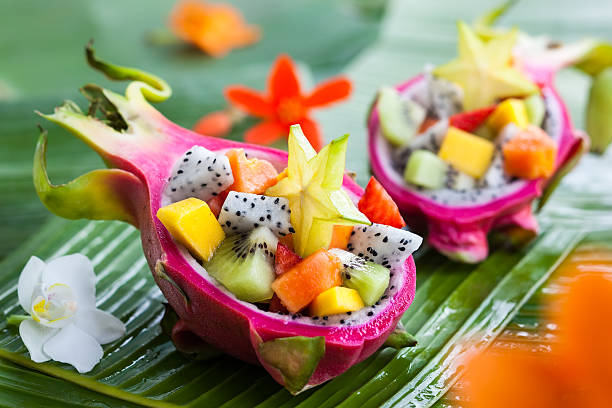 Exotic fruit salad Exotic fruit salad served in half a dragon fruit dragon fruit flower stock pictures, royalty-free photos & images