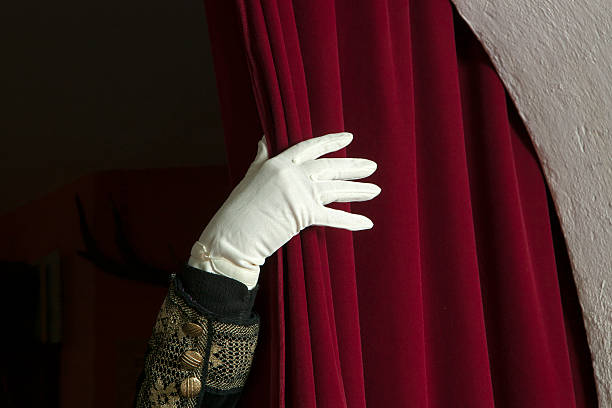 istock Hand in white gloves unveil the curtain. 475575251