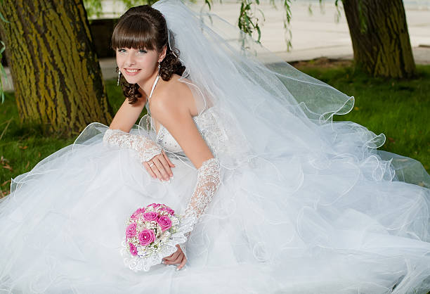 istock Young beautiful bride in wedding dress with a bouquet 475576341