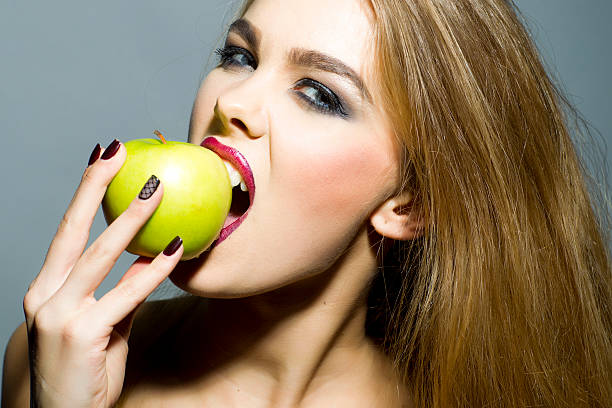 istock Passionate blonde woman with apple 475579036