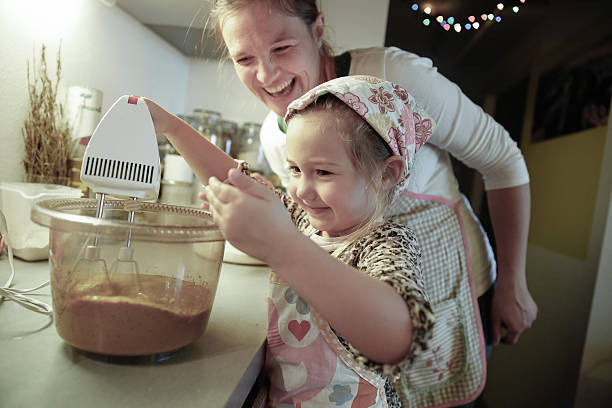 istock Mother smiling and tutoring her daughter in the kitchen 475579366