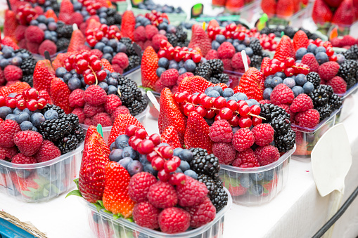 Mix of fresh berries in a baskets on a board